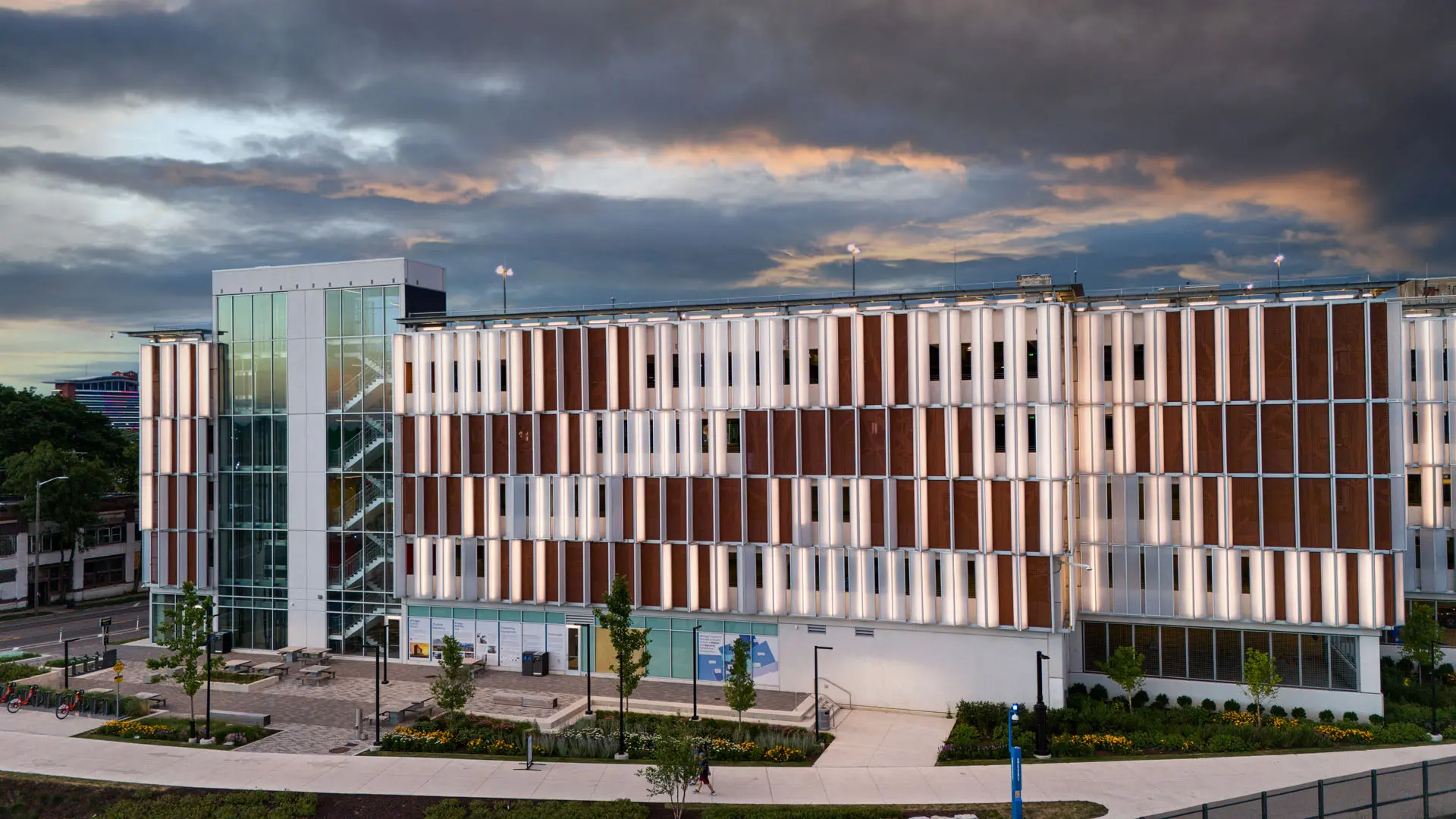 The Bagley Mobility Hub illuminated at twilight, showing the lit louvered facade
